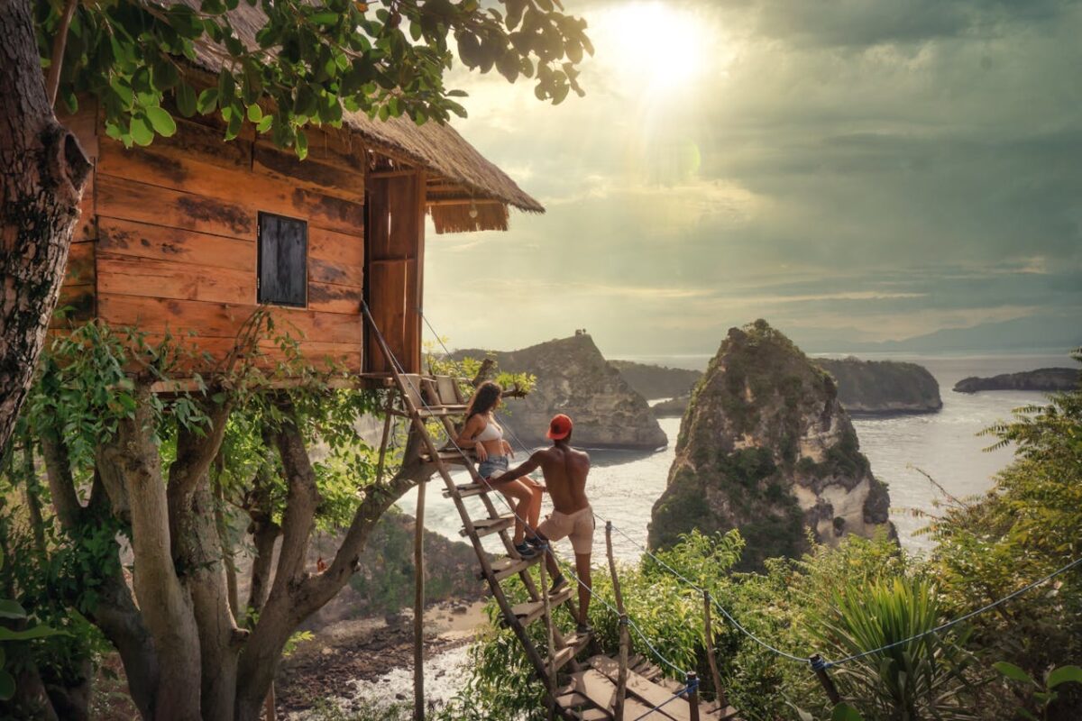 about-img Couple relaxing on a tree house with stunning ocean views in Bali, Indonesia.